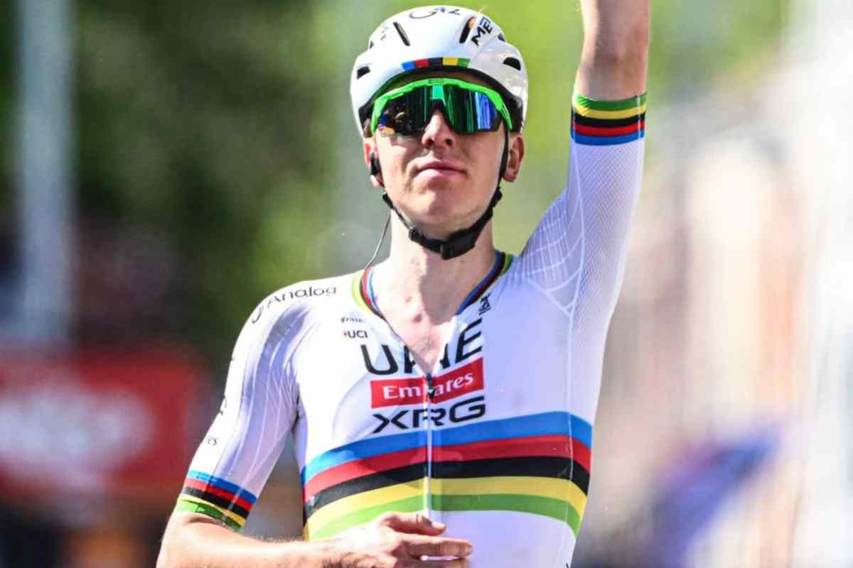 Tadej Pogacar alza il braccio al cielo dopo una vittoria